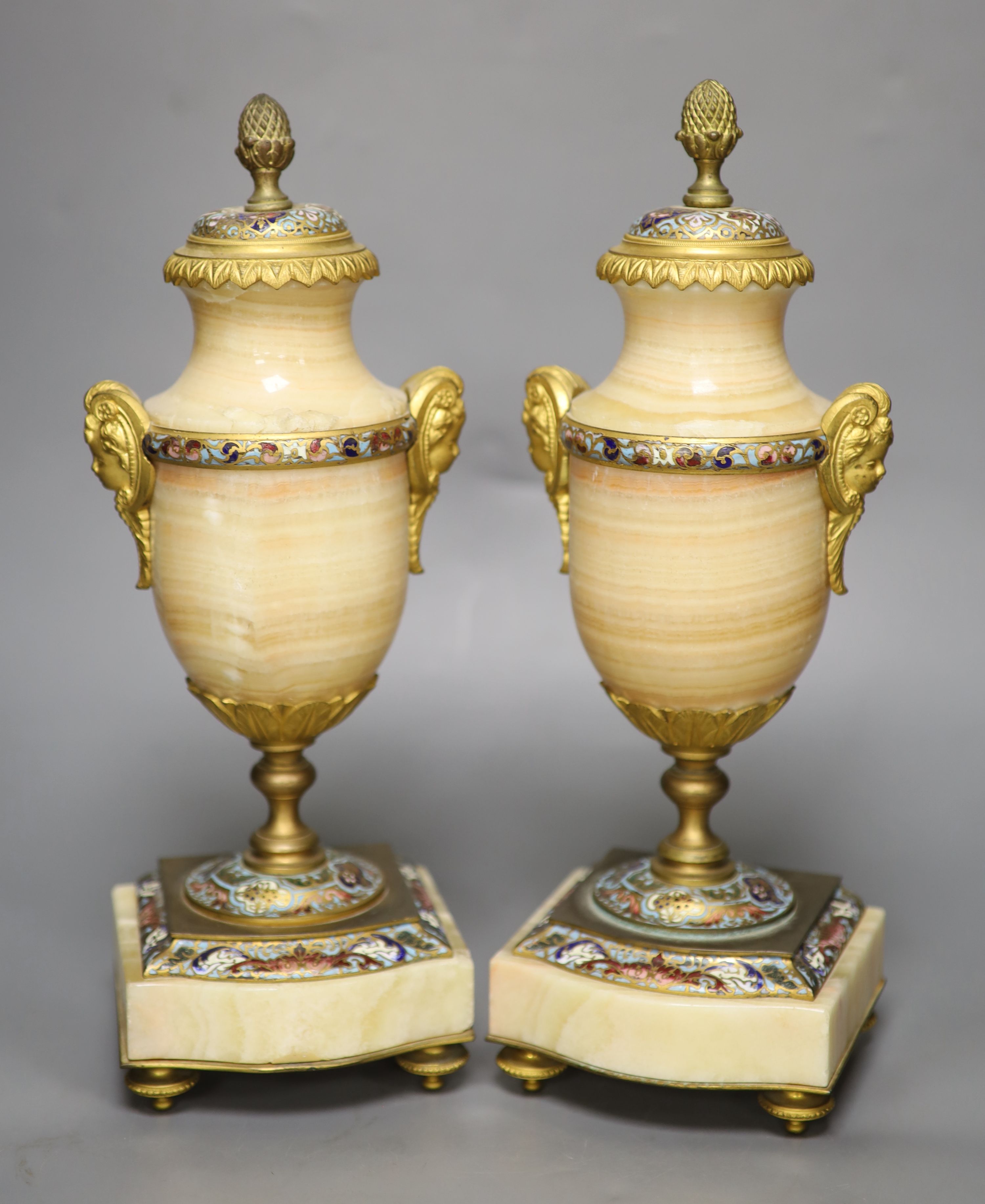 A pair of late 19th century alabaster and champleve enamel urns (formerly part of a clock garniture), height 32cm